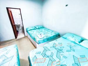 MoñitosHotel Palmahia Moñitos的一间卧室配有两张床和镜子