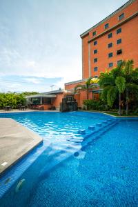 NaguanaguaHotel GH Guaparo INN的大楼前的大型蓝色游泳池