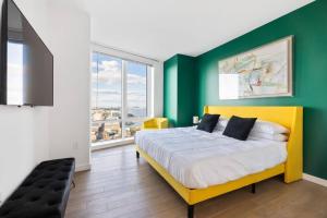 泽西市Modern 3 BR 3.5 BA Breathtaking的一间卧室设有一张黄色的床和绿色的墙壁