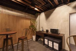 大阪3U NAMBA MINAMI by DOYANEN的厨房配有柜台、桌子和微波炉