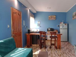 奥索尔诺CABAÑA OSORNO Ruta 215的厨房拥有蓝色的墙壁,配有桌椅