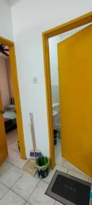 伯豪Homestay Atikah Bahau的浴室设有黄色门和瓷砖地板。