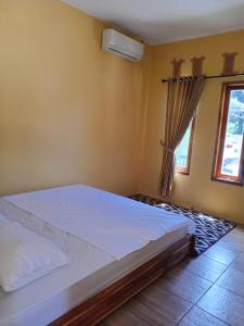 MalukAisyah Villa Sumbawa的卧室配有白色的床和窗户