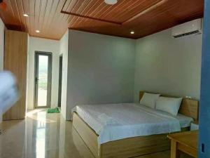 惹岛Biển Xanh Homestay的一间卧室设有一张木天花板床。