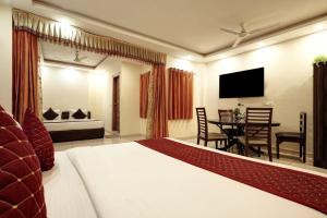 新德里Airport Hotel IVY的一间卧室配有一张床、一张桌子和一台电视