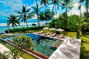 甘地达萨吉塔塞加拉别墅的一个带躺椅的游泳池和海洋