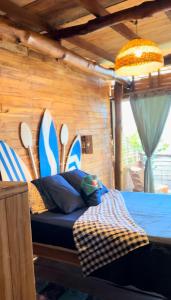 布兰卡滩BARU MAGGYBEACH的一间设有一张床铺的房间,墙上设有冲浪板