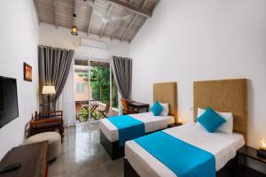 斯里贾亚瓦德纳普拉科特Angam Suites Colombo的酒店客房设有两张床和电视。