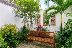 斯里贾亚瓦德纳普拉科特Angam Suites Colombo的花园里种有树木和植物的木凳
