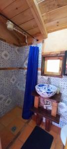 锡帕基拉Venta del Espino的浴室设有水槽和蓝色的浴帘
