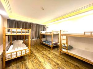 西哈努克Fusion Hotel的客房设有三张双层床,铺有木地板。
