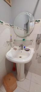 卡拉奇Maymar Holiday Home的浴室设有白色水槽和镜子