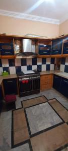 卡拉奇Maymar Holiday Home的厨房拥有蓝色和白色的瓷砖墙壁