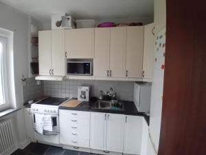 马尔默Naza cool villa!的厨房配有白色橱柜、水槽和微波炉