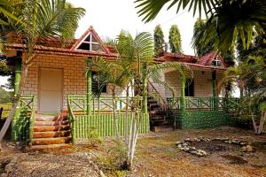 JalpāiguriAyush Jungle Resort的前面有绿色围栏的房子