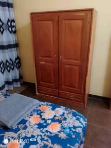 KétouOluwa-Sheyi Apartment in Ketou的一间卧室配有一张床和一个木制橱柜
