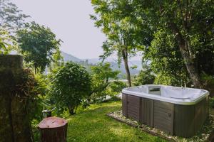 清迈Muangkham Cabin的浴缸坐在树旁的草上
