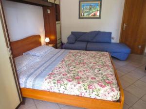 梅杜林Ferienwohnung für 2 Personen ca 28 qm in Medulin, Istrien Südküste von Istrien的一间卧室配有一张床和一张蓝色的沙发