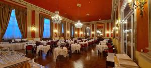 圣雷莫德隆德雷斯格兰德酒店的宴会厅配有白色的桌椅和吊灯