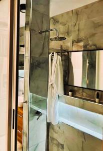 阿什杜德Luxury open-space apartments by the sea的带淋浴、毛巾和盥洗盆的浴室