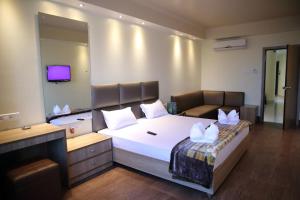 古瓦哈提Mayur Residency Hotel的卧室配有带白色枕头的大床