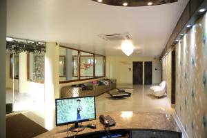 古瓦哈提Mayur Residency Hotel的一间带电视和沙发的客厅