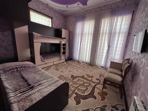 撒马尔罕Almotrudiy apartament的一间卧室配有一张床,并在一间客房内配有电视。