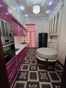 撒马尔罕Almotrudiy apartament的厨房配有桌子和黑冰箱。