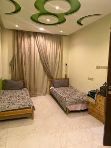 欧奈宰سفانه的一间卧室设有两张床和绿色的天花板