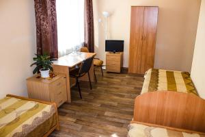 喀山那贝雷兹诺迷你酒店的酒店客房配有两张床、一张书桌和一张书桌。