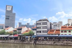 新加坡Heritage Collection on Boat Quay - South Bridge Wing的一座有建筑的城市和一条有火车的河流