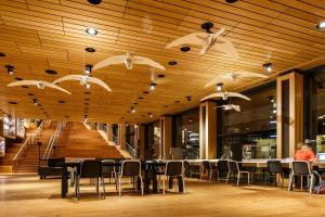 阿纳姆阿纳姆智选假日酒店的餐厅设有桌椅和木制天花板。