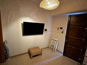 福利尼奥Casa in centro的客厅的墙上配有平面电视。
