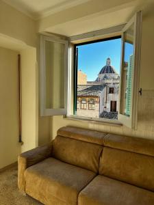 福利尼奥Casa in centro的沙发,坐在窗户前,享有美景