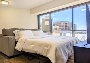 檀香山Modern 1Bdrm Oceanview with Parking的一间卧室设有一张床和一个大窗户