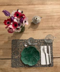 滨海萨纳里Maison d hôtes LA VILLA MADELEINE的一张桌子,上面有盘子和花瓶
