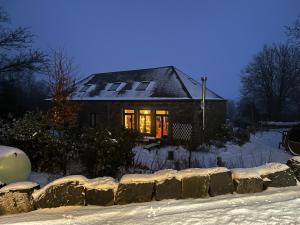 维尔雅尔姆Ecole Buissonnière的雪中的房子,灯亮