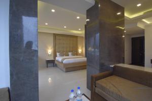 焦特布尔Gourav Lodge的一间卧室配有一张床和一张沙发,桌子上配有水瓶