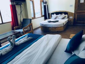 钱德加尔DevDham Lodge的酒店客房,配有两张床和椅子