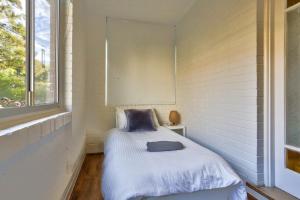 悉尼Charming 3 Bedroom on the edge of Downtown Glebe的窗户客房内的小床
