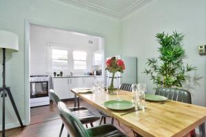 悉尼Charming 3 Bedroom on the edge of Downtown Herford St 2 E-Bikes Included的厨房以及带木桌和椅子的用餐室。