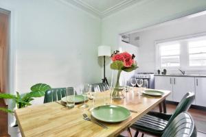 悉尼Charming 3 Bedroom on the edge of Downtown Glebe的一张带绿椅和花瓶的餐桌