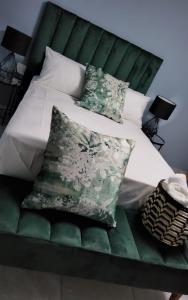 MʼBazwaneAFRICAN DREAM LODGE MBAZWANA的一张带绿色床头板和枕头的床