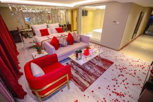 欧奈宰Cheerful Al Waha Hotel Unayzah - فندق شيرفل عنيزة的带沙发和红色椅子的客厅