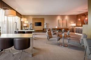 维琴察维琴察万豪AC酒店的酒店客房设有一间带桌椅的客厅