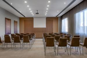 维琴察维琴察万豪AC酒店的一个带椅子和投影屏幕的会议室