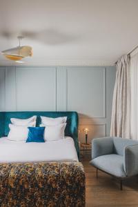 波尔多Hôtel Singulier Bordeaux的一间卧室配有一张床和一张蓝色椅子