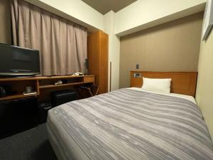 旭川旭川站一条通路特客栈及酒店的酒店客房,配有床和电视
