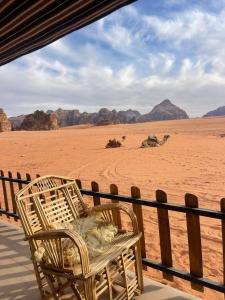 瓦迪拉姆Wadi Rum Magic Camp的坐在沙漠门廊上的藤椅