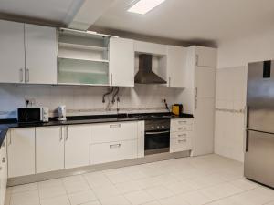 卡斯卡伊斯Villa dos castanheiros的厨房配有白色橱柜和不锈钢用具
